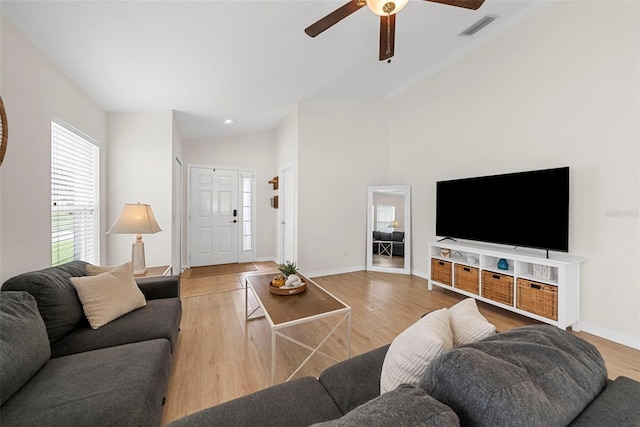 living room featuring ceiling fan, lofted ceiling, and wood-type flooring