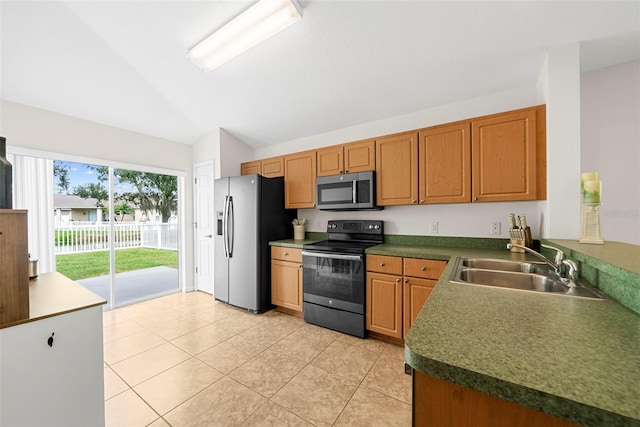 kitchen featuring lofted ceiling, sink, light tile patterned floors, and stainless steel appliances