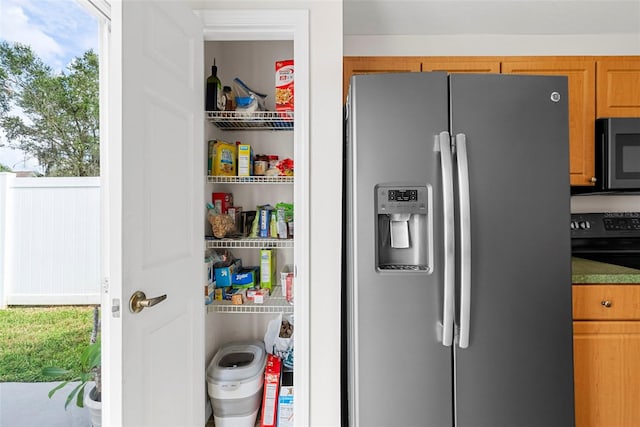 interior space with electric range and stainless steel fridge with ice dispenser