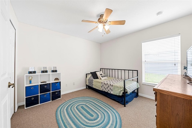 carpeted bedroom with ceiling fan and a closet