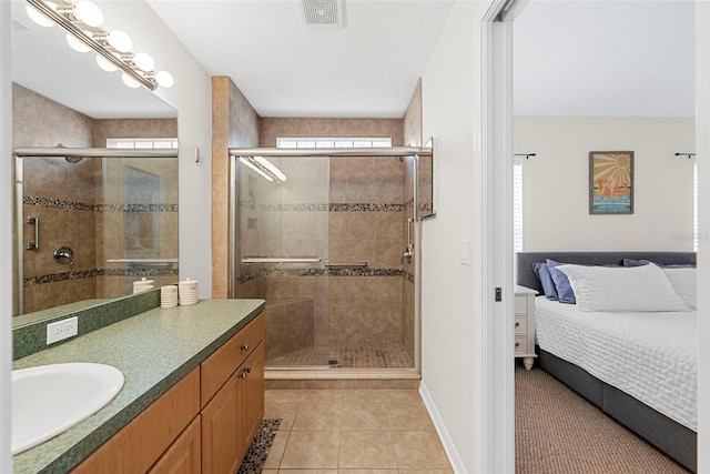 bathroom with a healthy amount of sunlight, vanity, tile patterned floors, and an enclosed shower