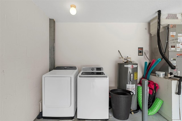 laundry area with water heater and washing machine and clothes dryer