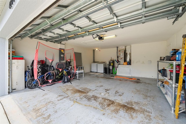 garage with washing machine and clothes dryer, a garage door opener, and water heater