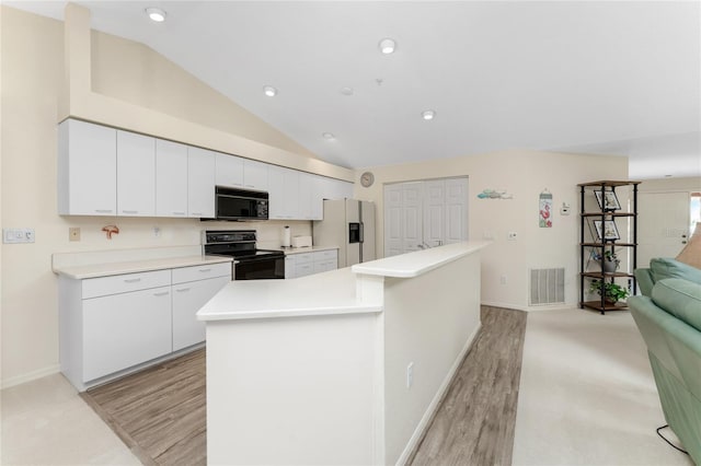 kitchen with white cabinets, a kitchen island, light hardwood / wood-style flooring, black appliances, and vaulted ceiling