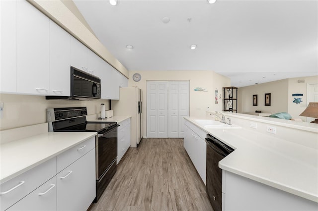 kitchen with black appliances, sink, light hardwood / wood-style flooring, and white cabinets