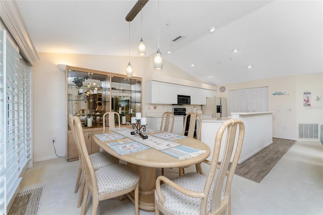 dining space featuring a wealth of natural light, vaulted ceiling, and light colored carpet