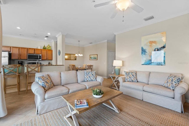 living room featuring ceiling fan with notable chandelier, light tile patterned flooring, and ornamental molding