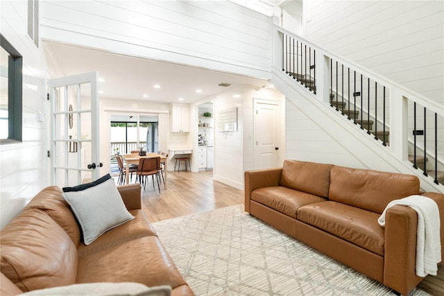 living room with light hardwood / wood-style flooring and a towering ceiling