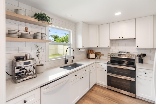 kitchen featuring dishwasher, sink, white cabinets, light hardwood / wood-style flooring, and stainless steel electric range