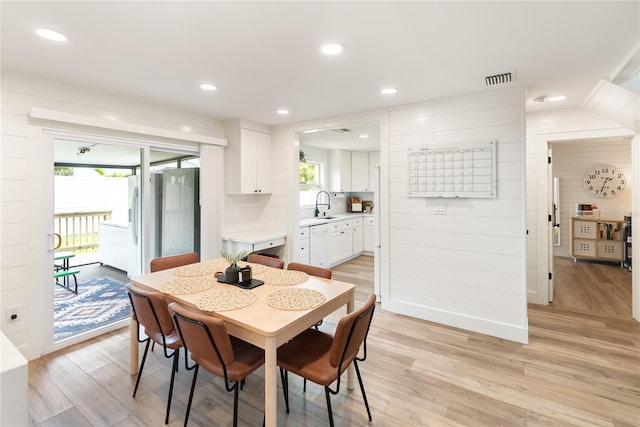 dining area featuring light wood-type flooring and sink