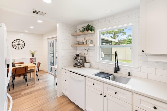 kitchen featuring light wood-type flooring, white dishwasher, white cabinetry, and sink