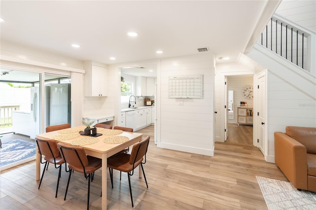 dining area with sink and light hardwood / wood-style flooring