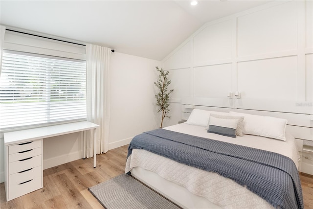 bedroom featuring lofted ceiling and light wood-type flooring