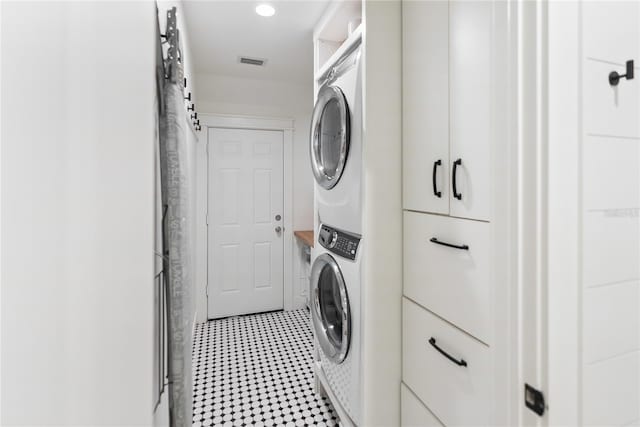 washroom featuring stacked washer / drying machine