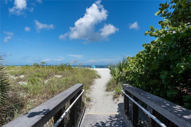 view of community featuring a water view and a beach view