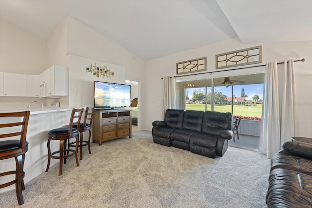 carpeted living room with high vaulted ceiling