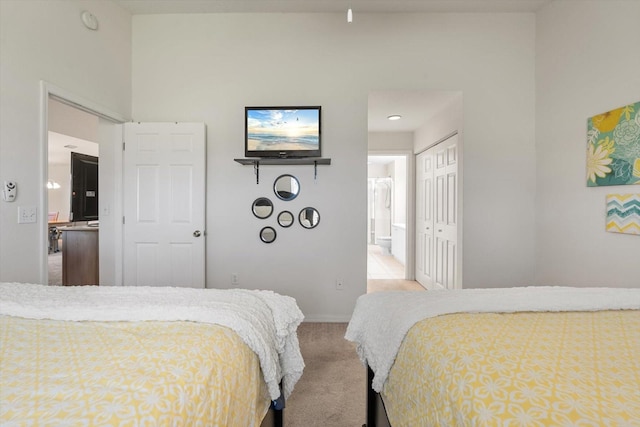 carpeted bedroom featuring ensuite bathroom and a closet