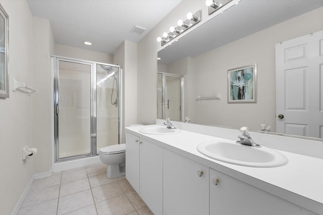 bathroom featuring tile patterned flooring, vanity, toilet, and a shower with shower door