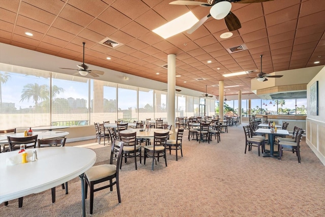 dining space with ceiling fan and carpet flooring