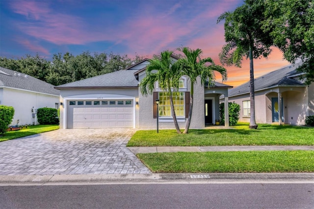 view of front of home featuring a garage and a yard