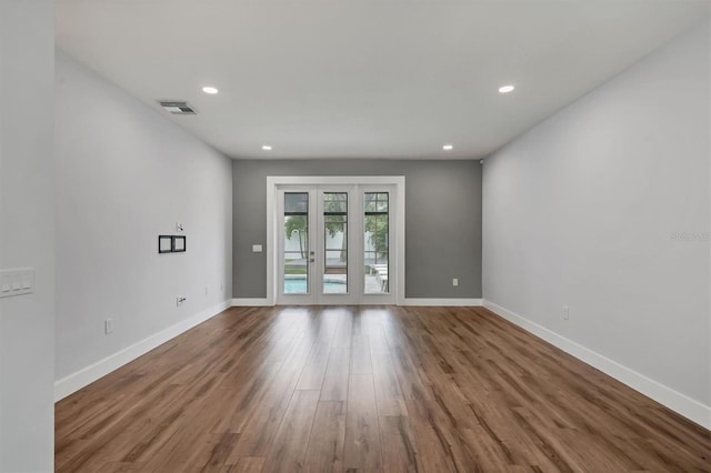 spare room featuring french doors and hardwood / wood-style flooring