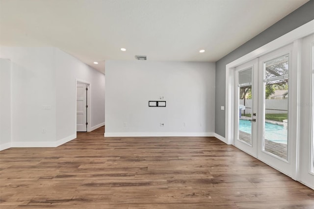 empty room featuring wood-type flooring and french doors