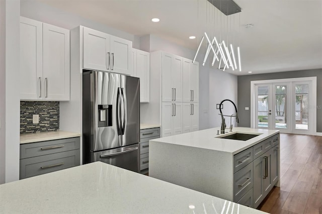 kitchen featuring dark hardwood / wood-style flooring, gray cabinets, decorative light fixtures, sink, and stainless steel fridge with ice dispenser