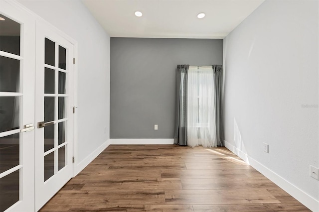 spare room with wood-type flooring and french doors