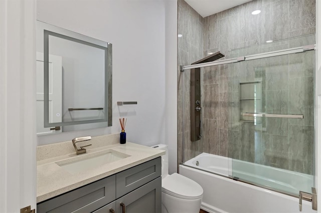 full bathroom featuring enclosed tub / shower combo, vanity, and toilet