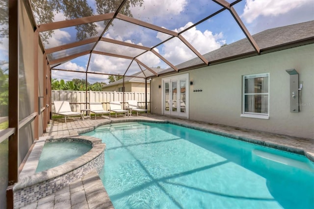 view of pool featuring a patio, glass enclosure, an in ground hot tub, and french doors