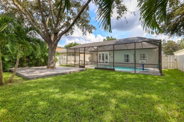 rear view of property with a lanai, a fenced in pool, a lawn, and a patio area