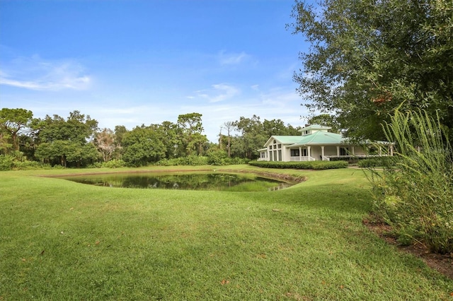 view of yard with a water view and covered porch