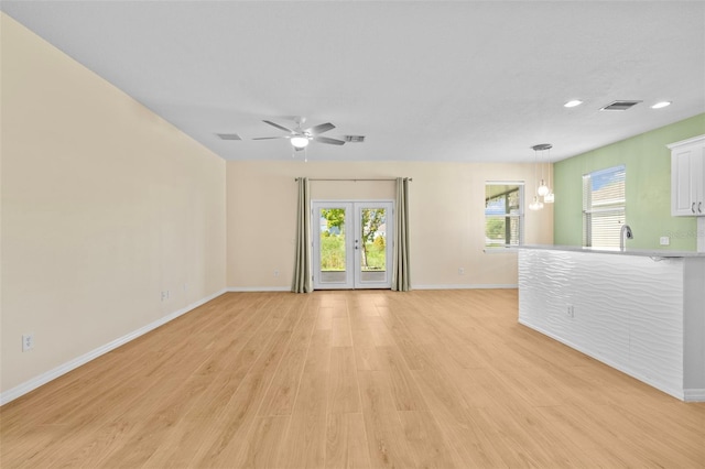 unfurnished living room featuring light hardwood / wood-style floors, ceiling fan, and french doors