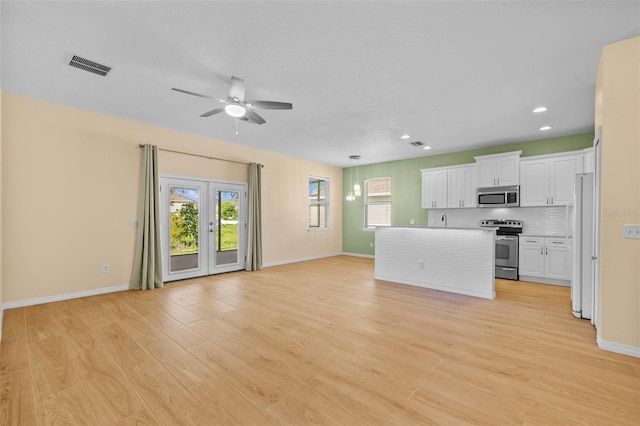 kitchen featuring a center island, white cabinetry, light hardwood / wood-style flooring, stainless steel appliances, and ceiling fan