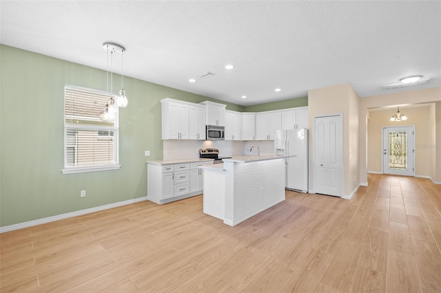 kitchen featuring appliances with stainless steel finishes, a kitchen island with sink, light hardwood / wood-style flooring, and white cabinetry