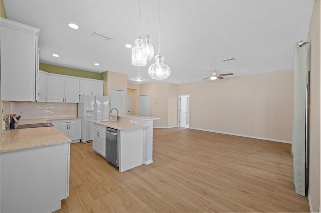 kitchen with light hardwood / wood-style floors, ceiling fan with notable chandelier, white cabinets, an island with sink, and stainless steel dishwasher