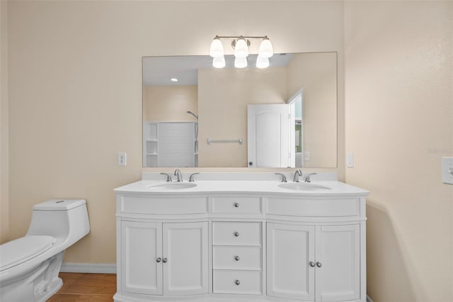 bathroom featuring walk in shower, wood-type flooring, vanity, and toilet