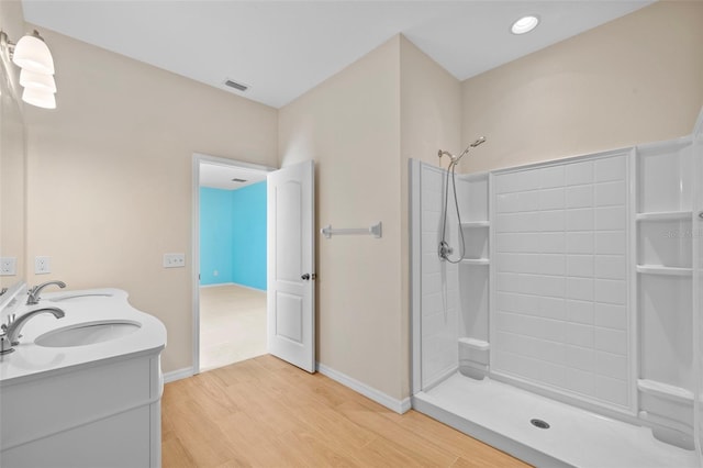 bathroom featuring walk in shower, wood-type flooring, and vanity