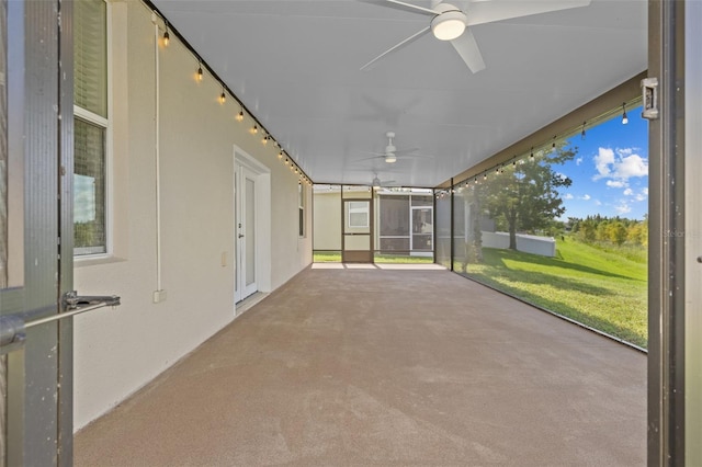 unfurnished sunroom with ceiling fan