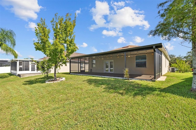 back of house featuring a sunroom, central air condition unit, and a yard