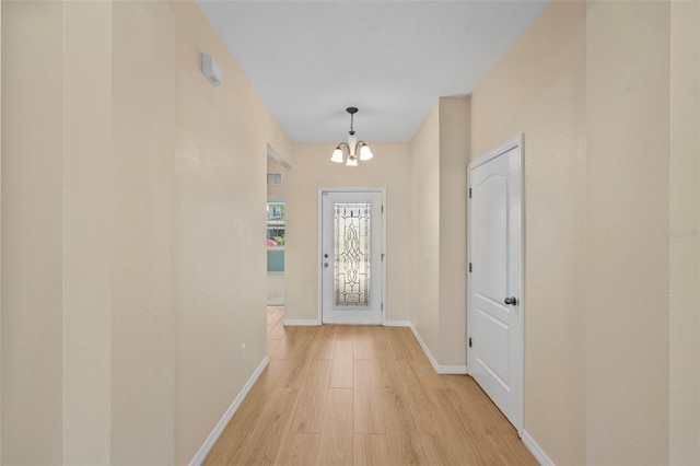 doorway to outside featuring light hardwood / wood-style flooring and a chandelier