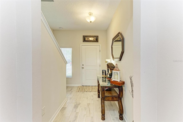 entryway featuring a textured ceiling and light wood-type flooring