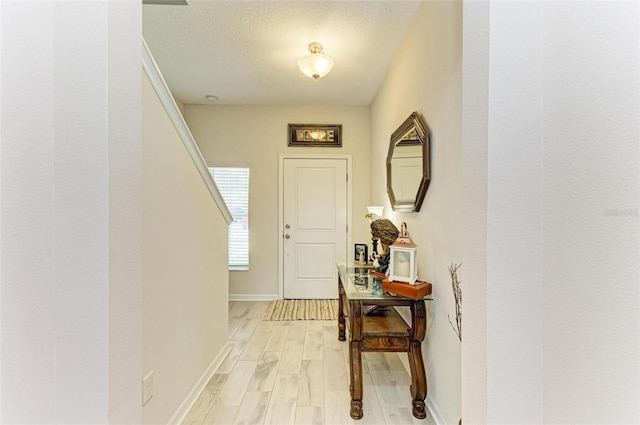 entryway featuring a textured ceiling and light wood-type flooring