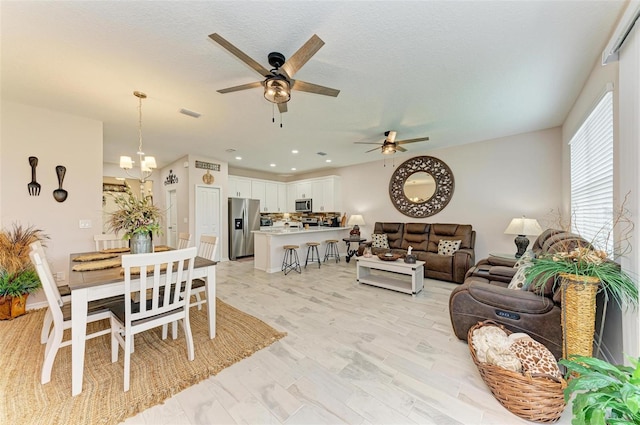 living room with light hardwood / wood-style flooring and ceiling fan