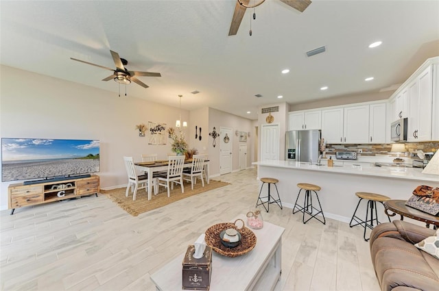 living room with light wood-type flooring and ceiling fan