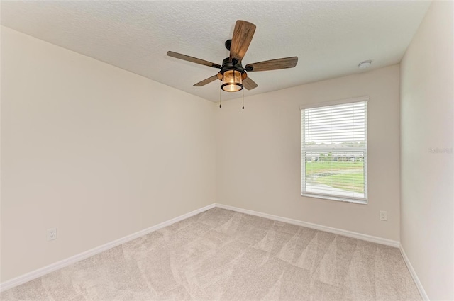 spare room with light carpet, ceiling fan, and a textured ceiling