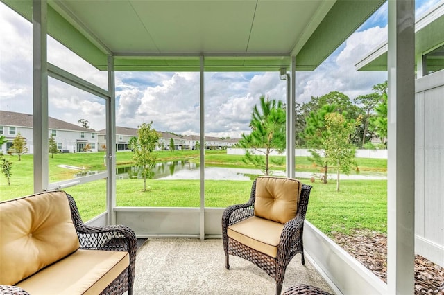 sunroom / solarium featuring a water view