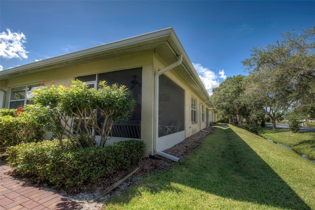 view of home's exterior with a yard and a sunroom