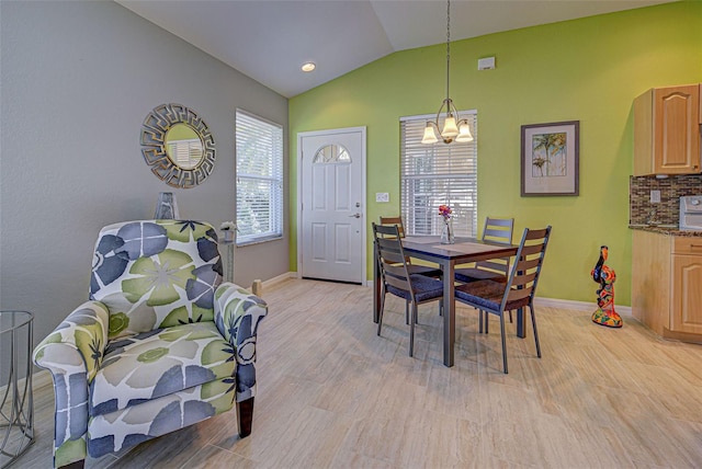 dining space featuring lofted ceiling, light hardwood / wood-style floors, and a chandelier