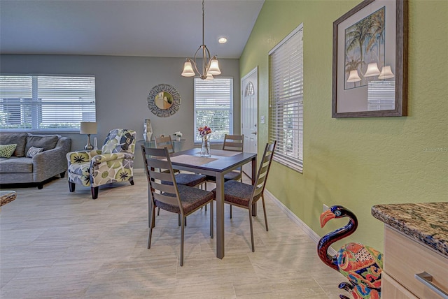 dining space featuring vaulted ceiling and a chandelier